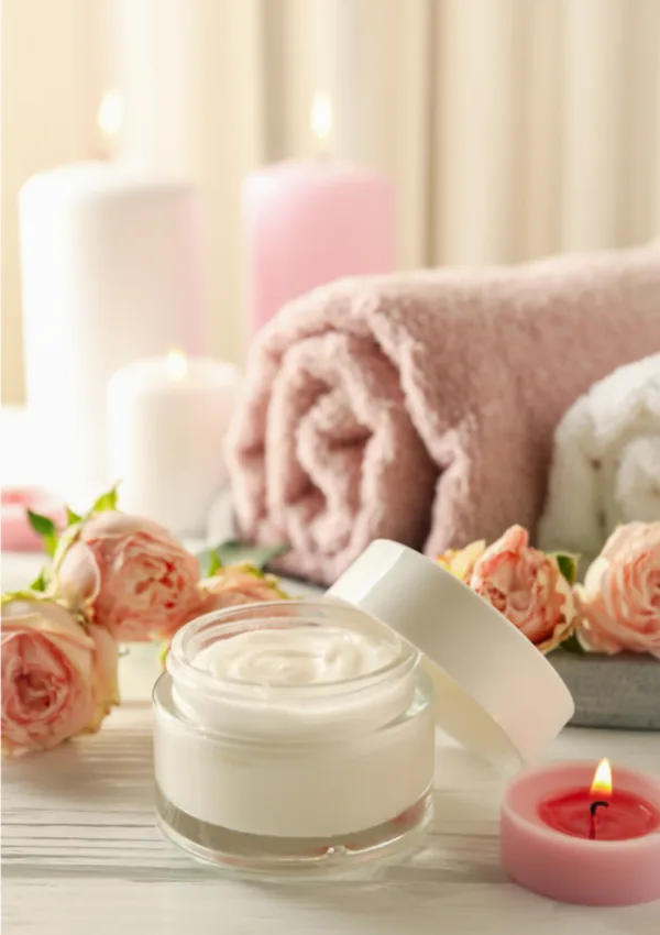 Donna in accappatoio che applica creme profumate per il corpo sulla gamba. Immagine che ritrae una routine di cura personale e l'uso di creme per il corpo profumate per idratare e ammorbidire la pelle.