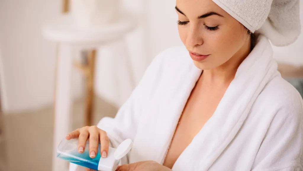 10 Detergenti viso essenziali per la tua routine 4 Mujer echandose limpiador facial