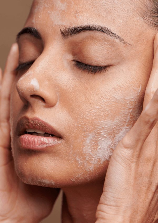 Donna che applica prodotti sul viso durante la sua Routine Viso Pelle Grassa e Mista.