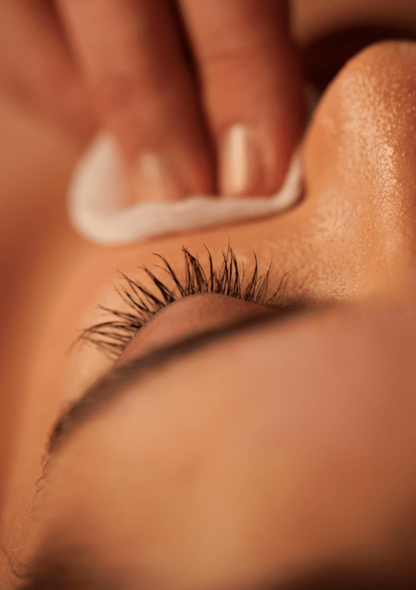 Donna con pelle grassa che utilizza un dischetto di cotone per rimuovere il sebo in eccesso dal viso