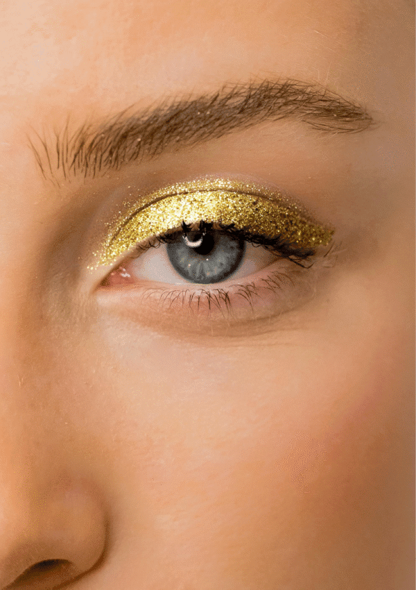 Occhio con ombretto liquido dorato glitterato