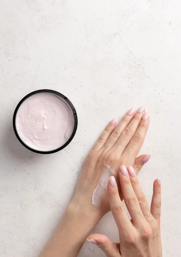 Mani che applicano crema idratante con barattolo di crema aperto